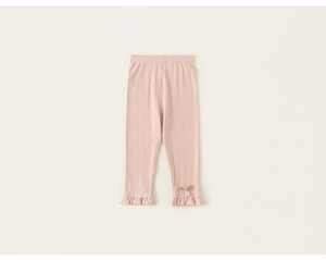 Detail of pink ribbed knit leggings for girls with pearl flower brooch and ruffle hems