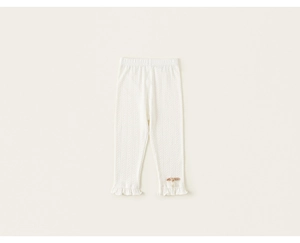 Detail view of baby girl knitted leggings with ruffles and a pink bow decoration