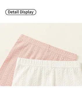 Close-up of elastic waistband and ribbed knit texture on pink and white leggings