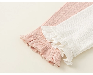 Detailed macro view of girls knitted ribbed leggings with sweet ruffled hem and bow accents