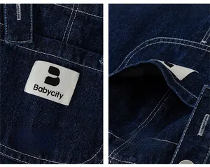 Detail of dark blue denim fabric with brand woven label and contrast stitching pocket