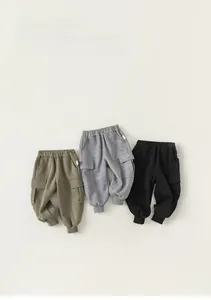 Flat lay of kids cotton jogger pants in green, gray, and black with cargo pockets