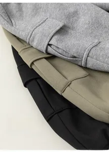 Detail of soft knit cotton pants with large cargo pockets in grey green and black colors