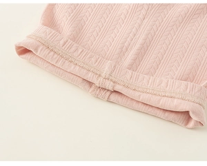 Close-up of pink ribbed knit fabric detail with intricate patterns for girls' leggings