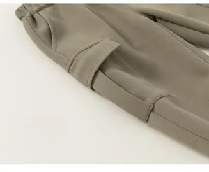 Detailed close-up of the flap pocket and durable fabric on olive green cargo pants
