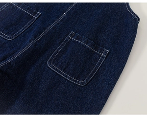 Close-up of dark blue denim fabric texture and white contrast stitching on pocket