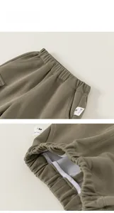 Detail of army green kids trousers showing elastic waistband and stitching on the inner tape