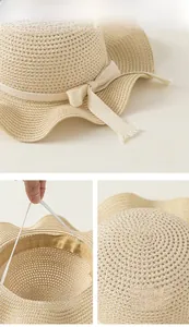Dettaglio cappello di paglia a trama traforata con fiocco e cordino elastico regolabile