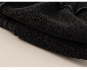 Close-up of soft black fleece lining for children pants showing warm texture and fabric quality