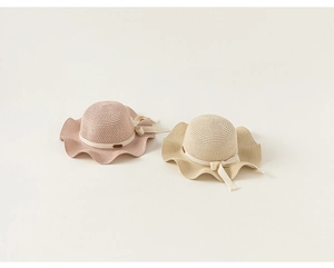 Texture dettagliata di cappelli di paglia per bambine con fiocchi in rosa e beige