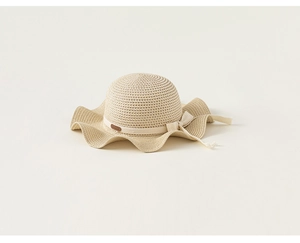 Dettaglio cappello di paglia per bambina con trama intrecciata e fiocco elegante