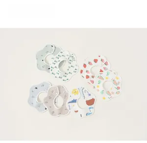 Détail de 7 bavoirs en coton en forme de pétale avec divers motifs fruits et animaux