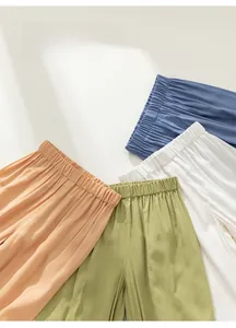 Detail of lightweight summer mosquito pants for kids in blue, green, and orange colors