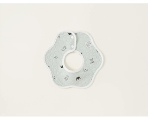 Détail d'un bavoir bébé vert clair en coton matelassé avec des motifs de couronnes nordiques