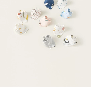 Mise à plat de plusieurs bavoirs pour bébé en coton avec imprimés floraux et dessins