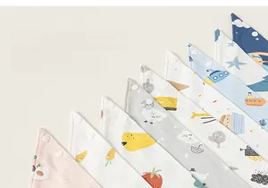 Détail de bavoirs en coton pour bébé avec imprimés cartoon et fermetures à pression