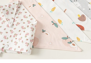 Détail de bavoirs en coton imperméable pour bébé avec motifs fleurs et fruits