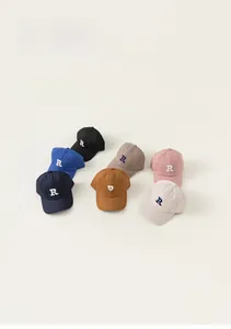 Flat lay of vintage style kids baseball caps with R embroidery in seven various colors