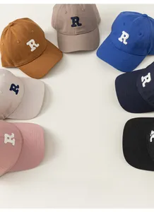 Flat lay of multiple cotton baseball caps in various colors with a towel embroidered R logo