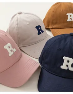 Detailed close-up showing stitching and R-letter embroidery on colorful kids' baseball caps
