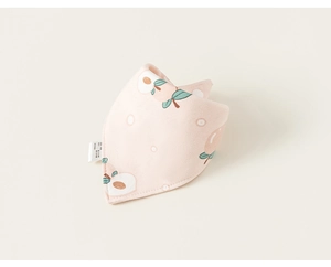 Détail d'un bavoir bébé en coton rose clair avec motifs de pêches et texture douce