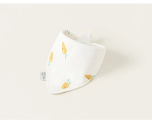 Détail d'un bavoir en coton doux pour bébé avec motif carotte et étiquette latérale