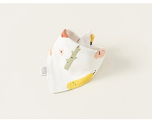 Détail d'un bavoir en coton pour bébé avec imprimé arbres colorés et fermeture à pression