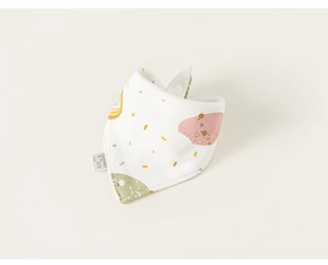 Détail d'un bavoir en coton pour bébé avec imprimé arc-en-ciel et bouton-pression blanc