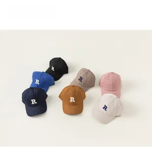 Flat lay of colorful cotton baseball caps with embroidered R letter in seven colors