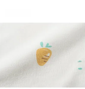 Gros plan du bavoir en coton imperméable avec motif imprimé de carottes jaunes