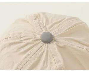 Detailed view of child sun hat crown with grey top button and reinforced stitching
