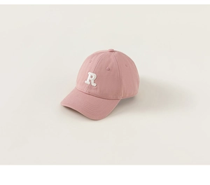 Macro shot of pink cotton baseball cap featuring white 3D embroidered letter R detail