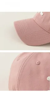 Close-up of pink cotton baseball cap with fine stitching and embroidered eyelet details