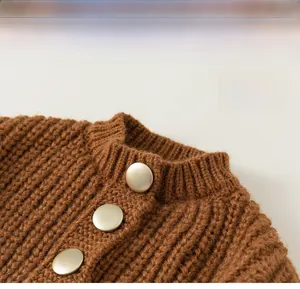 Detail view of brown chunky knit cardigan featuring classic round neck and gold buttons