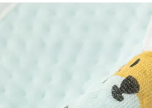 Gros plan d'un bavoir en coton imperméable pour bébé avec texture gaufrée et motifs animaux
