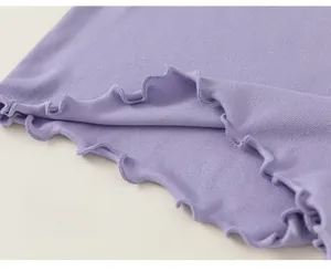 Dettaglio maglia bimba color lavanda in tessuto a coste con bordo a volant sulla base