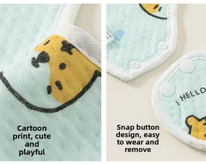 Détail de bavoir en coton pour bébé avec texture gaufrée bleue et boutons-pression