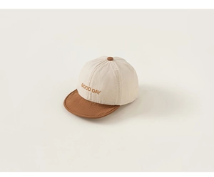 Detailed macro view of beige and brown kids baseball cap with GOOD DAY embroidery