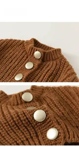 Detail view of warm brown chunky knit cardigan with gold vintage buttons and ribbed neckline