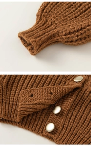 Close-up of brown chunky knit cardigan featuring ribbed cuffs and matte metal buttons