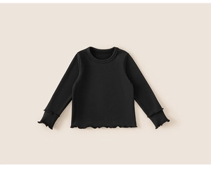 Dettaglio della maglia nera a maniche lunghe per bambini con eleganti bordi a volant