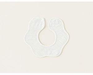Gros plan d'un bavoir bébé en coton blanc avec texture mousseline et boutons pression