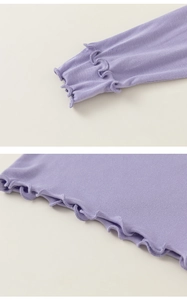 Dettaglio maglia a coste lavanda per bambini con bordi a volant su polsini e orlo