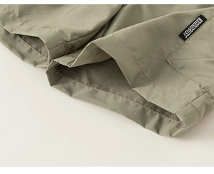 Detailopname van de olijfkleurige cargoshort met duurzame stof en merk geweven label