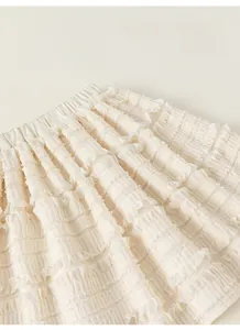 Detail of white layered ruffle cake skirt with elastic waistband and soft mesh fabric texture