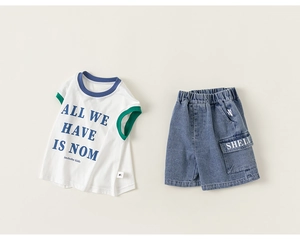 Detail of boys summer set showing white tank top with blue trim and denim shorts with pockets