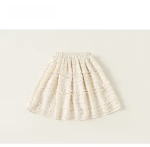 Detailed view of kids layered cream cake skirt with elastic waistband and pleated fabric