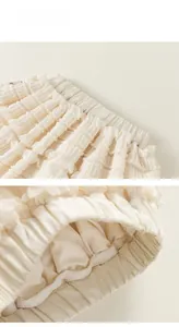 Detail view of the elastic waist and layered ruffle textures on a cream cake skirt