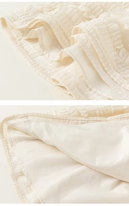 Close-up of girls beige pleated tiered skirt showing ruffle detail and lining