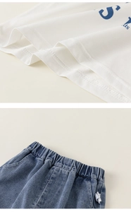 Detailed close-up of cotton T-shirt stitching and elastic waistband on denim shorts